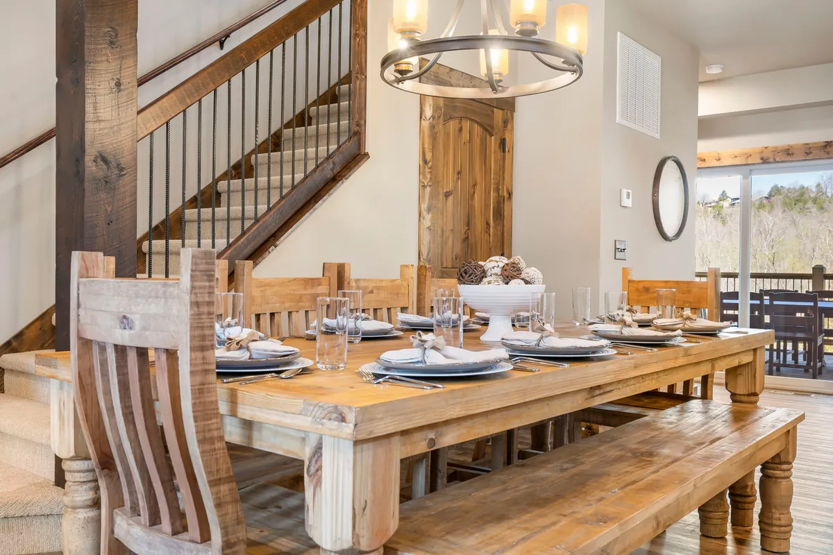 This photo centers on a large wooden dining table beneath a rustic chandelier, styled simply but elegantly. The space is set up for family meals, gatherings with friends, or festive celebrations, embodying the section’s theme of togetherness at the table.